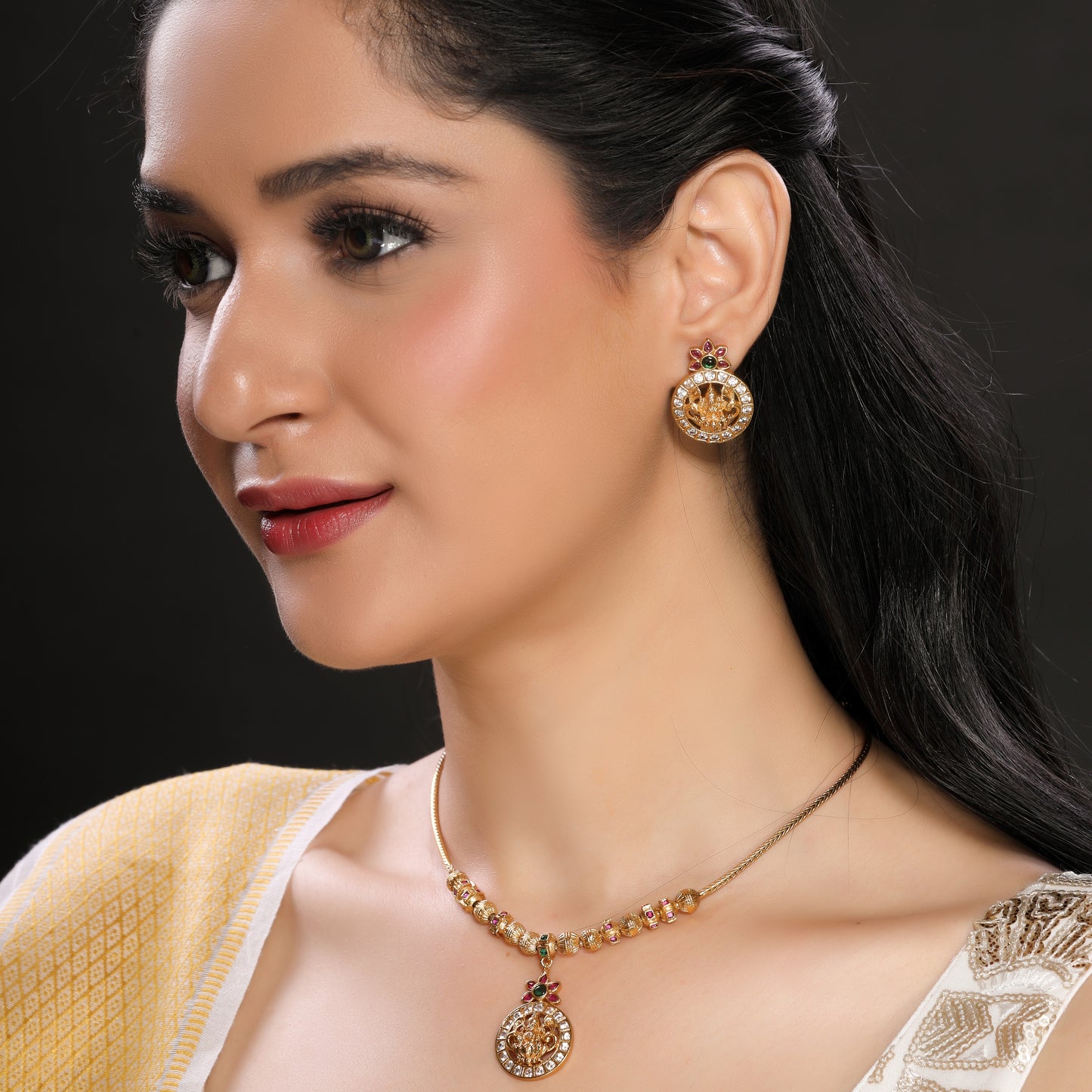 Modern yet Traditional Elegant Temple Laxmi Pendant Necklace Set with Danglers in Matte Finish Gold Plated Brass studded with Zirconia, Ruby, Green Crystals