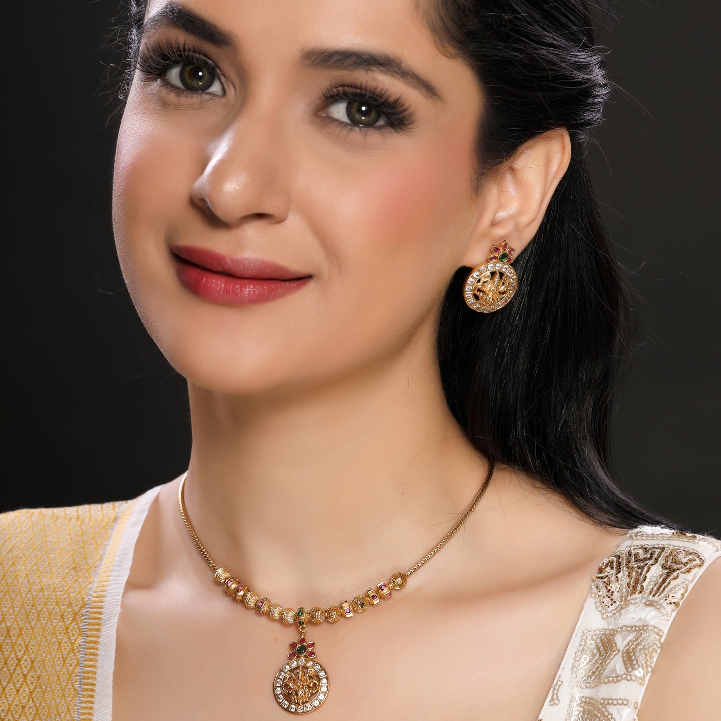 Modern yet Traditional Elegant Temple Laxmi Pendant Necklace Set with Danglers in Matte Finish Gold Plated Brass studded with Zirconia, Ruby, Green Crystals