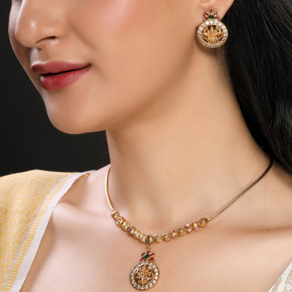 Modern yet Traditional Elegant Temple Laxmi Pendant Necklace Set with Danglers in Matte Finish Gold Plated Brass studded with Zirconia, Ruby, Green Crystals